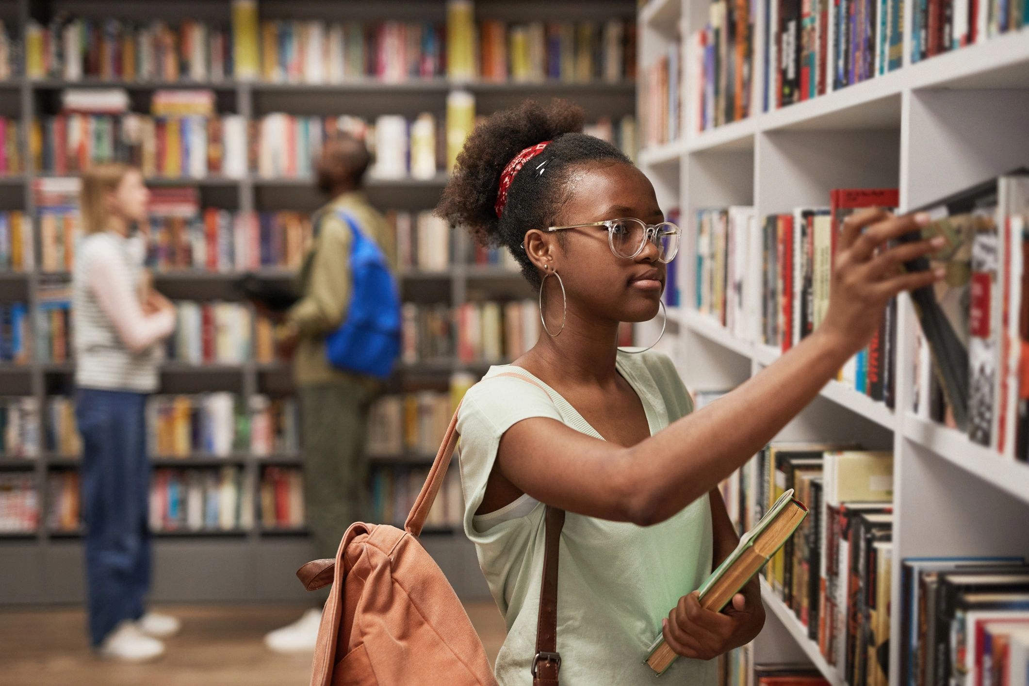 Friendly woman in a bookstore setting holding books